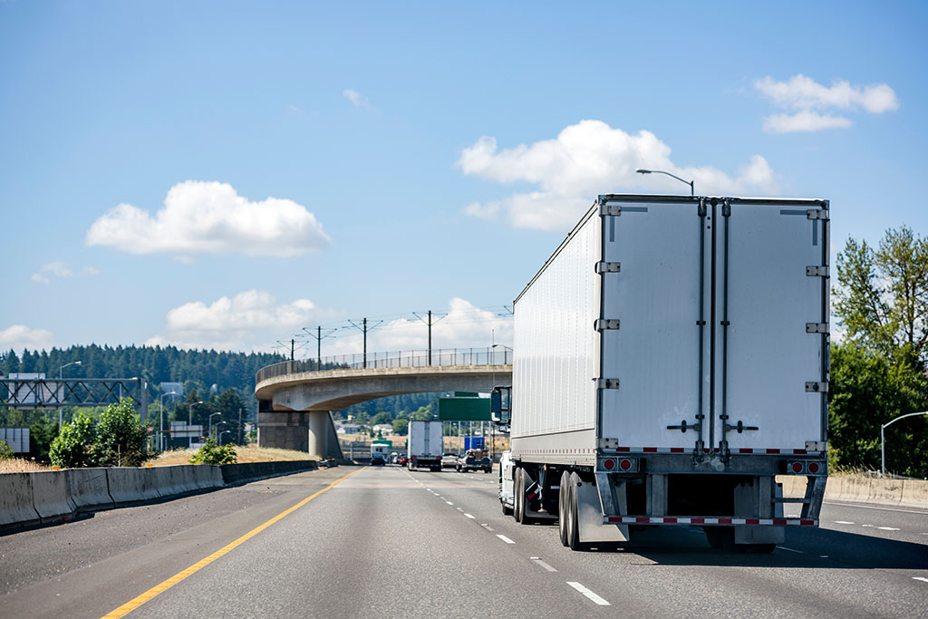 Big rig white semi truck transporting cargo